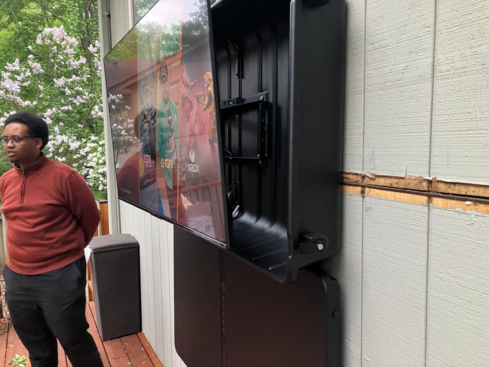 TC Mounting technician beside outdoor weatherproof TV enclosure